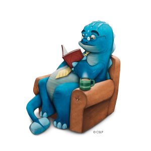 A blue cartoon dinosaur wearing glasses and a yellow tie sits in an armchair reading a book, with a steaming mug nearby.