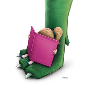 A girl sitting on a dinosaur's foot, reading a large pink book.